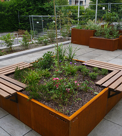 Jardinière en acier Corten avec des bancs intégrés aux Azalées à Bruxelles par Kubik