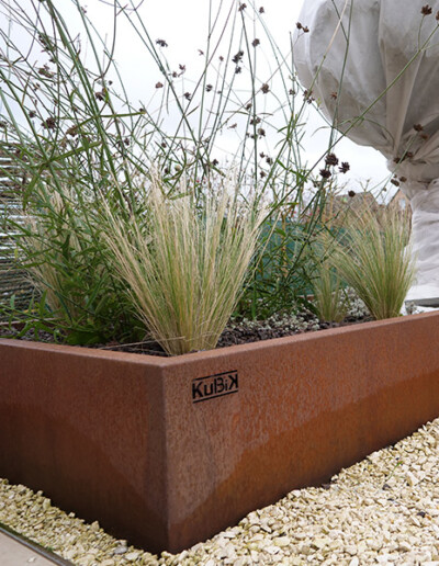 Jardinière sur mesure en acier Corten avec des graminées et des plantes créée par Kubik Création