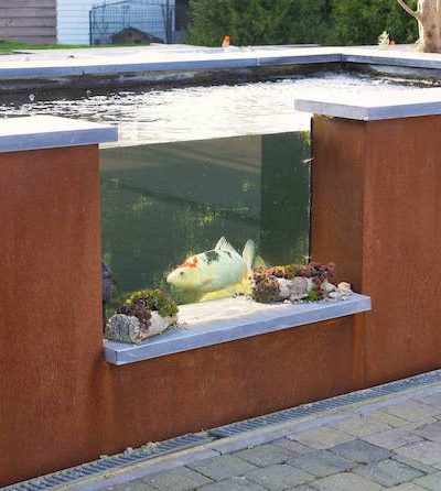 Plan d'eau en acier Corten avec une ouverture pour voir les poissons